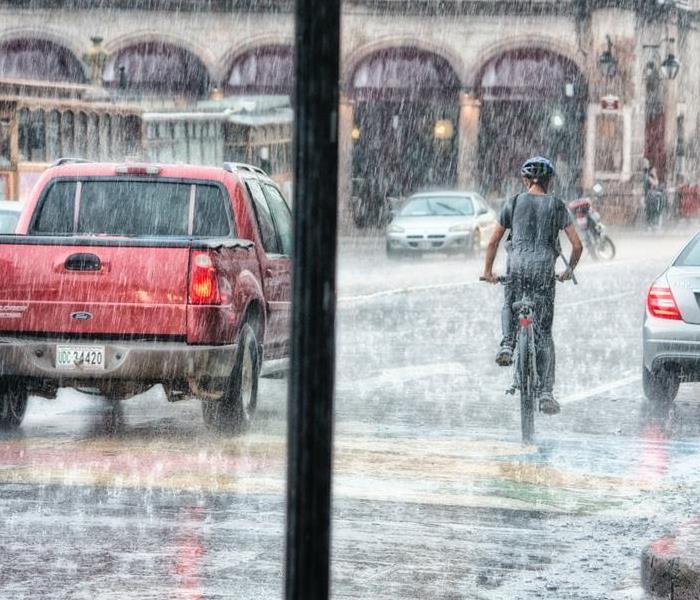 Man riding a bicycle in storm.